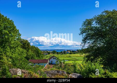 Paysage pittoresque avec maisons et propriétés et vue sur la côte, île de Koster Sud, Bohuslän, Västra Götalands län, Suède. Banque D'Images