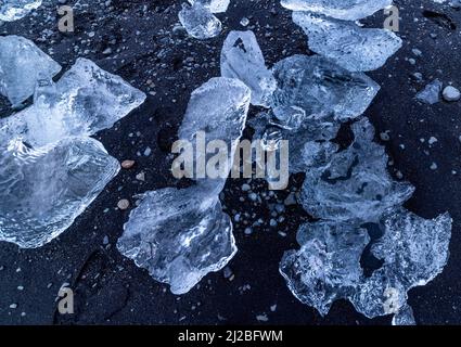 Fonte de glace sur sable noir à Diamond Beach, Breidamerkursandur, sud-est de l'Islande Banque D'Images