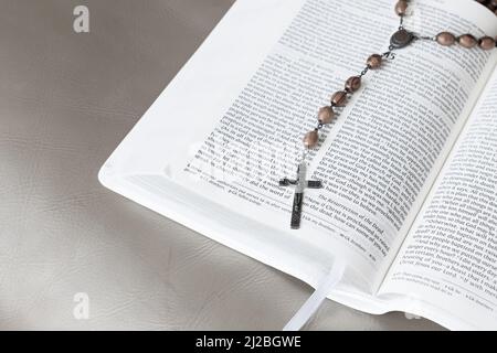 Perles de prière catholique Rosaire sur une Bible ouverte avec espace de copie Banque D'Images