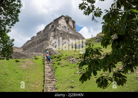 San Ignacio, Belize - 24 août 2019 : les touristes grimpant les escaliers escarpés jusqu'à la ruine Maya ensoleillée 'El Castillo' sur le site archéologique de Xunantunich Banque D'Images