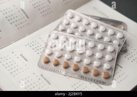 pilules contraceptives , calendrier et bloc-notes sur la table Banque D'Images