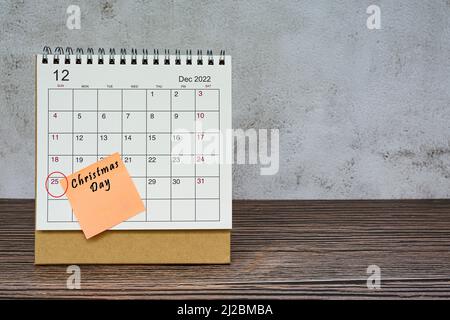 Calendrier de décembre 2022 sur bureau en bois avec cercle de date et texte sur le pense-bête. Le jour de Noël le 25th décembre 2022 Banque D'Images
