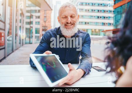 Homme d'affaires montre le graphique du marché boursier sur une tablette Banque D'Images