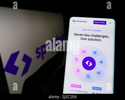 Personne tenant le téléphone portable avec la page web de la société française de technologie financière Spendesk SAS sur l'écran devant le logo. Concentrez-vous sur le centre de l'écran du téléphone. Banque D'Images