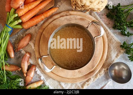 Bouillon d'os de bœuf dans une casserole en métal, avec légumes frais, vue de dessus Banque D'Images