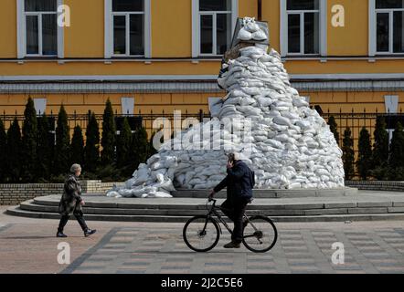 Kiev, Ukraine. 14th mars 2022. L'homme passe à vélo devant le monument de Mykhailo Hrushevsky, connu sous le nom d'académicien, politicien, historien et homme d'État ukrainien, qui a été l'une des figures les plus importantes de la renaissance nationale ukrainienne du début du 20th siècle couvert de sacs de sable pour le protéger des attaques de missiles de l'armée russe. La Russie a envahi l'Ukraine le 24 février 2022, déclenchant la plus grande attaque militaire en Europe depuis la Seconde Guerre mondiale (Credit image: © Sergei Chuzavkov/SOPA Images via ZUMA Press Wire) Banque D'Images