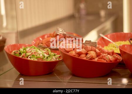 Distribution de nourriture, buffet, restauration. Légumes dans des bols rouges Banque D'Images