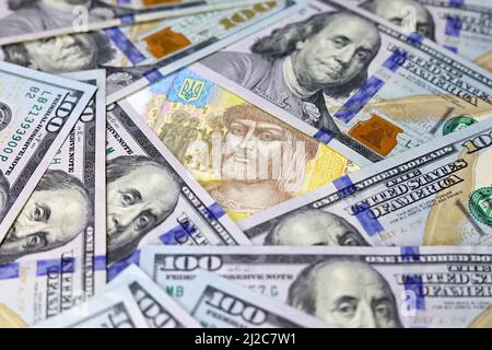 Hryvnia ukrainien entouré de billets en dollars américains. Concept de l'aide américaine à l'Ukraine, taux de change Banque D'Images