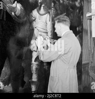 Restaurateur H.H. Mertens du Rijksmuseum travaillant sur Rembrandt van Rijn Night Watch ca: 1946 Banque D'Images