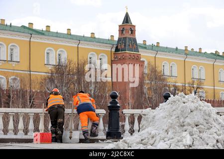 Deux travailleurs avec des pelles se tenant sur fond de Kremlin de Moscou. Travailleurs migrants pendant le repos, nettoyage des rues au printemps, déneigement Banque D'Images