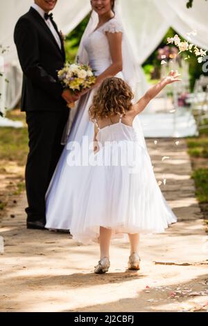 Pétales de rose volante de mariage des enfants lors de la cérémonie Banque D'Images
