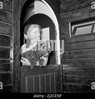 SEPHA van Beinum-Janssen, l'épouse du chef Eduard van Beinum, avec le coolé David dans ses bras, regarde à travers la porte semi-ouverte de leur maison de campagne à Garderen ca: 5 juin 1954 Banque D'Images