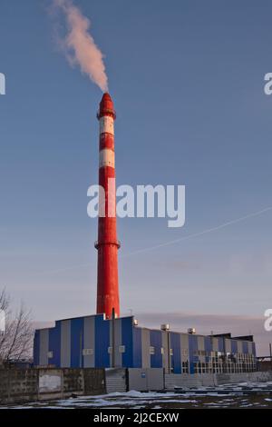 Chaufferie de quartier avec grande cheminée en béton rouge. Objet du système d'alimentation en chaleur de la ville. Banque D'Images