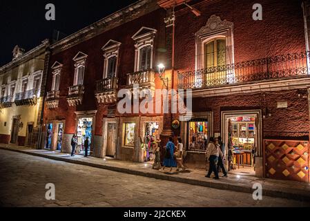 Une rangée de bâtiments bordant une rue pavée la nuit dans la ville de San Miguel de Allende, Guanajuato, Mexique Banque D'Images