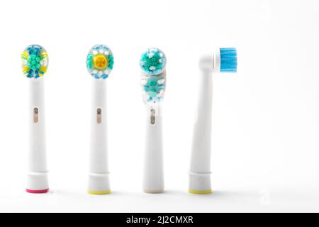 quatre têtes de brosse à dents électriques de rechange se sont dressées une face sur le côté, isolées du fond blanc, personne Banque D'Images