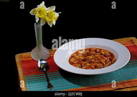 Un bol de ragoût de poisson maison composé de pétoncles, crevettes, calmars, muscles et poisson blanc récoltés de façon durable. Banque D'Images