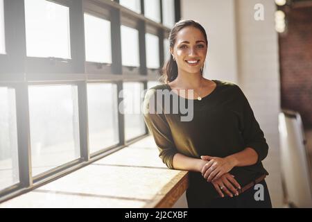 La confiance en soi est tout si vous voulez réussir. Portrait d'une jeune femme d'affaires confiante debout à une fenêtre dans un bureau. Banque D'Images