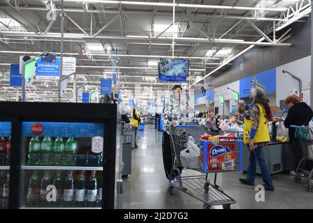 Une femme qui pousse un chariot d'épicerie dans un quartier très animé de Walmart à Cheyenne, Wyoming - 2021 août Banque D'Images