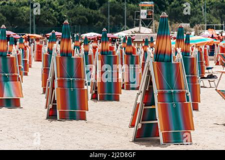 Les chaises longues pliées et les parasols sur la plage de sable dans une station de Portoroz, en Slovénie Banque D'Images