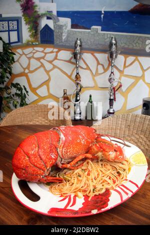 Grand homard avec pâtes sur la table du restaurant. Banque D'Images