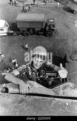 L'adolescent Steve Harrison a gravit les hauteurs du mur d'escalade du corps d'armée royale, dans le cadre de l'exposition d'entraînement d'aventure de l'armée à l'exposition d'été de Tyneside. 2nd août 1985. Banque D'Images