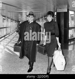 Elton John avec son épouse Renate arrivant de Los Angeles, à l'aéroport de London. 17 octobre 1986. Banque D'Images