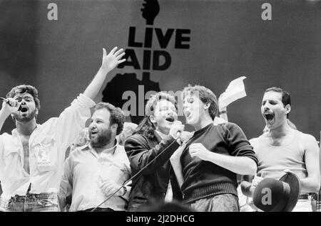 Concert à deux salles Live Aid, le 13th juillet 1985, au stade Wembley à Londres, en Angleterre, et au stade John F. Kennedy à Philadelphie, en Pennsylvanie, aux États-Unis. Les concerts ont été organisés en tant que suivi du single de Band Aid « Do ils savent son Noël ? » De recueillir de l'argent pour les victimes de la famine en Éthiopie. Les images montrent George Michael, promoteur Harvey Goldsmith, chanteur en chef de U2 Bono et Paul McCartney qui se présentent sur scène pendant la finale du concert à Wembley. Banque D'Images