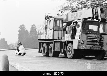 Le nouveau véhicule électrique Joe Paine, 14 ans, de Londres, essaie le nouveau véhicule électrique de Sir Clive Sinclair. Ici, il conduit par le côté d'un camion pour montrer la petite taille du véhicule C5. Photo prise le 10th janvier 1985 Banque D'Images