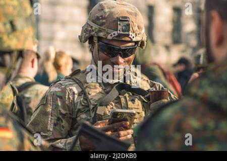 Soldat souriant du corps des Marines des États-Unis avec des lunettes de soleil, un fusil de chasse et un véhicule blindé humvee en arrière-plan pendant la guerre, les troupes des États-Unis ou de l'armée américaine Banque D'Images