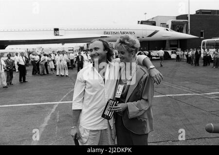Chanteur Phil Collins et femme Jill Travelman à l'aéroport de Londres Heathrow. Phil Collins est sur le point d'embarquer pour un vol Concorde vers les États-Unis, afin de se produire au stade JFK de Philadelphie, dans le concert Live Aid. Phil a déjà joué au concert Live Aid correspondant au stade Wembley. 13th juillet 1985. Banque D'Images