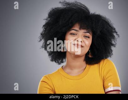 La confiance est charmante. Photo en studio d'une jeune femme attrayante posant sur un fond gris. Banque D'Images