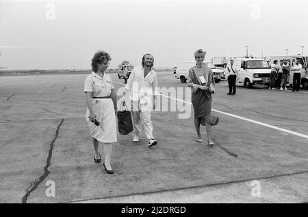 Chanteur Phil Collins et femme Jill Travelman (à droite) à l'aéroport de Londres Heathrow. Phil Collins est sur le point d'embarquer pour un vol Concorde vers les États-Unis, afin de se produire au stade JFK de Philadelphie, dans le concert Live Aid. Phil a déjà joué au concert Live Aid correspondant au stade Wembley. 13th juillet 1985. Banque D'Images