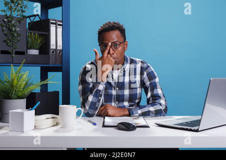 Jeune employé de bureau suspect et incertain, peu sûr des choix de gestion des clients potentiels de l'entreprise. L'employé de l'agence de marketing a été surpris et confus par la politique de travail révisée sur le lieu de travail. Banque D'Images