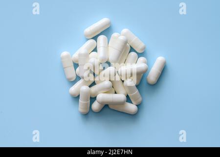 Bouquet de pilules blanches sur fond bleu Banque D'Images