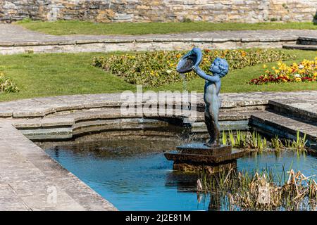 Statue d'une fontaine de Cherub dans un étang dans les jardins de la crique marine de Burnham on Sea, Somerset, Royaume-Uni Banque D'Images