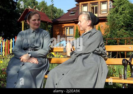 Augustów, Pologne, Polen, Polska, deux religieuses sont assis sur un banc et parlent. Zwei Nonnen sitzen auf einer Bank und unterhalten sich. Siostry zakonne Banque D'Images