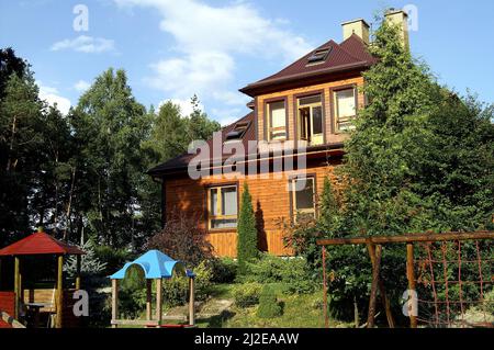 Augustów, Pologne, Polen, Polska, grande maison en bois entourée d'arbres. Hörderstraße, Umpen von Bäumen. Duży drewniany dom otoczony drzewami. Banque D'Images