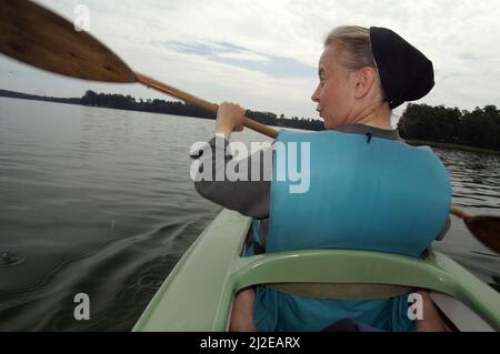 Augustów, Pologne, Polen, Polska, Une nonne de canoë dans une gilet de vie. Eine Nonne, die in einer Schwimmweste Kanu fährt. Kanufahren 穿著救生衣劃獨木舟的修女。 Banque D'Images