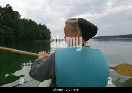 Augustów, Pologne, Polen, Polska, Une nonne de canoë dans une gilet de vie. Eine Nonne, die in einer Schwimmweste Kanu fährt. Kanufahren 穿著救生衣劃獨木舟的修女。 Banque D'Images