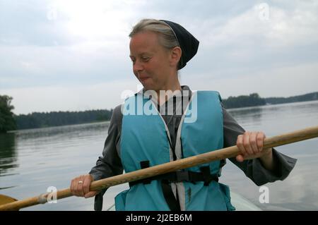 Augustów, Pologne, Polen, Polska, Une nonne de canoë dans une gilet de vie. Eine Nonne, die in einer Schwimmweste Kanu fährt. Kanufahren 穿著救生衣劃獨木舟的修女。 Banque D'Images