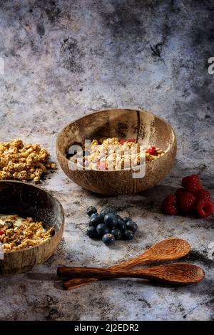 Granola saine avec fruits secs et noix sur un bol de yaourt. Bol en bambou avec des cuillères en bambou Banque D'Images