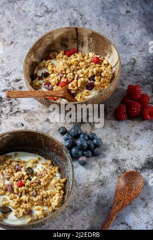 Granola saine avec fruits secs et noix sur un bol de yaourt. Bol en bambou avec des cuillères en bambou Banque D'Images