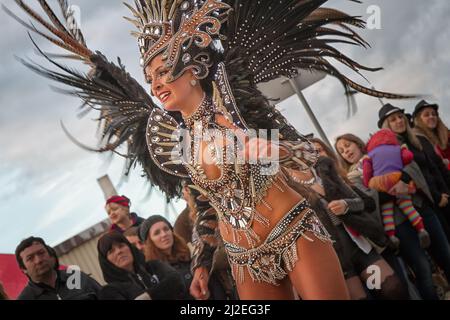 Portugal Carnaval, Mealhada - Femme en costume de plumes noir et or dansant samba avec Bate no Tambor. Banque D'Images