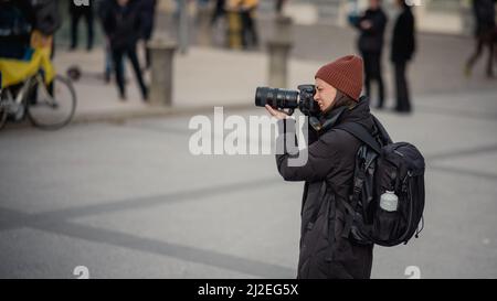 LJUBLJANA, SLOVÉNIE, 2,3.2022: Photographe féminin documentant les manifestations anti-guerre en faveur de l'ukraine contre l'opposition russe. Banque D'Images