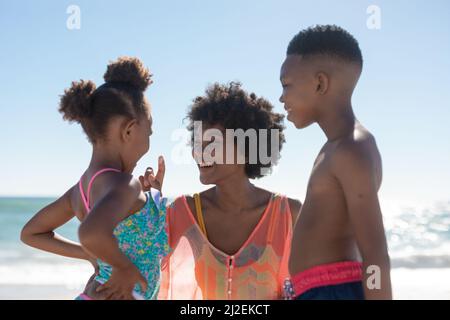 Joyeux mère afro-américaine avec son fils et sa fille en vacances d'été à la plage Banque D'Images