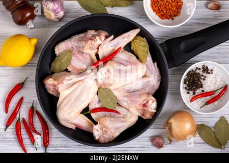 Vue de dessus poêle avec ailes de poulet crues aux épices. Banque D'Images