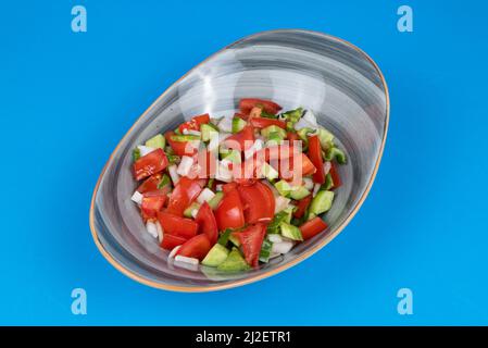 Vue rognée de la salade de berger prise de l'autre côté ou vue latérale sur fond bleu dans un cadre isolé. Banque D'Images
