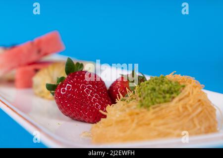 Image du dessert Güllace, de la baklava, des tranches de pastèque, de la canne à sucre, des fraises et du dessert kadayif. Banque D'Images