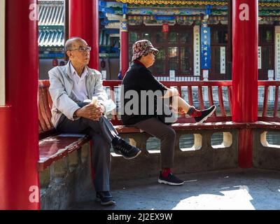 Un couple âgé s'assoit dans un parc le matin et apprécie la matinée en Chine Banque D'Images