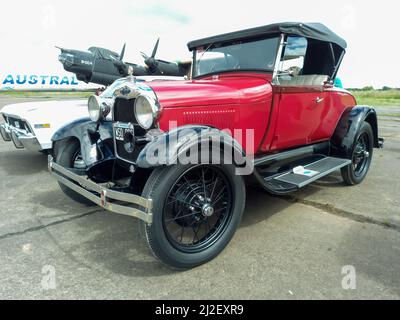 Vieux Ford rouge Un coupé roadster 1927-1937 garé dans une base pneumatique. Bombardier de la Seconde Guerre mondiale en arrière-plan. Salon automobile classique CADEAA MNA 2022. CopySpace. Banque D'Images